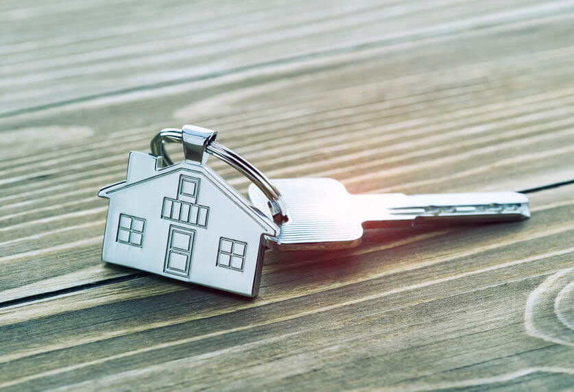 keychain with house symbol and keys on wooden background,Real es